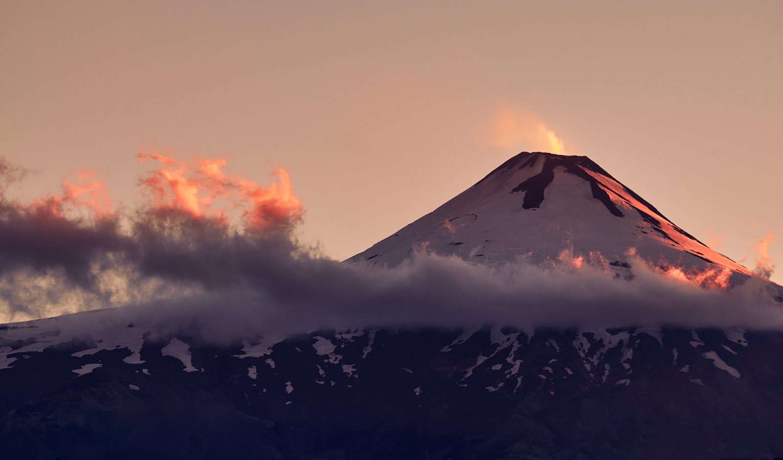 Mesmerizing view of the Villarrica volcanic mountain gleaming under the pink sky during sunset